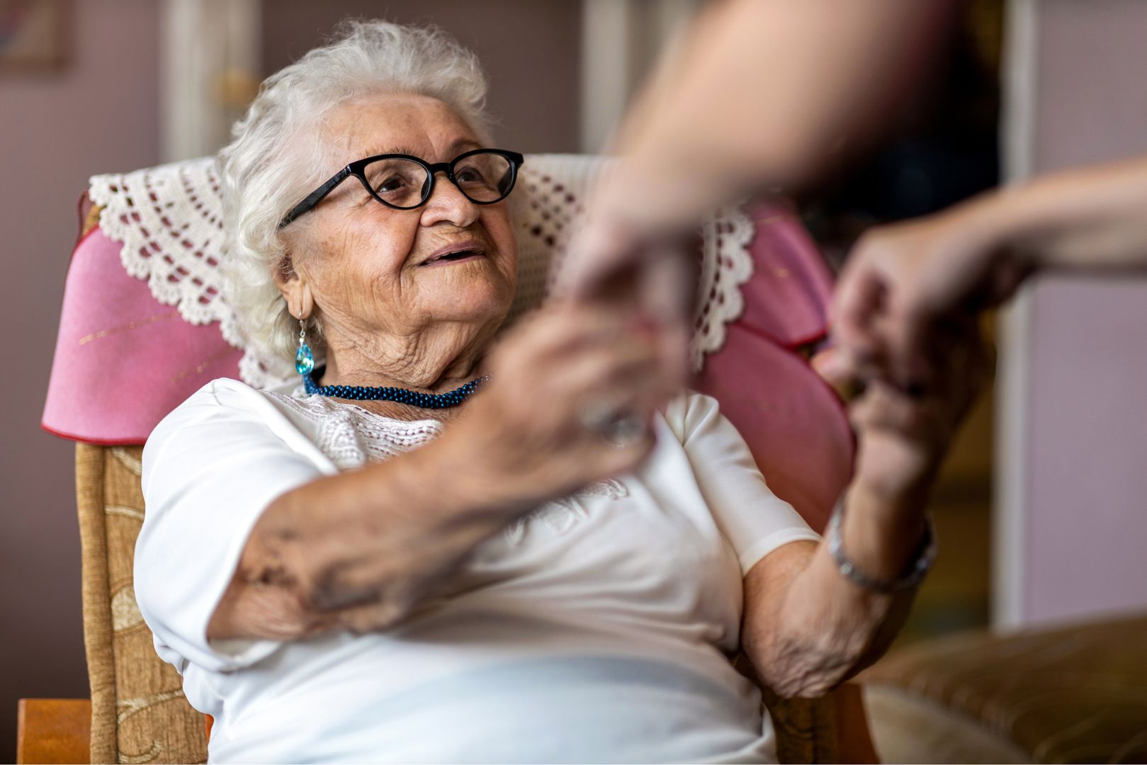Ältere Frau bekommt Hilfe beim Aufstehen